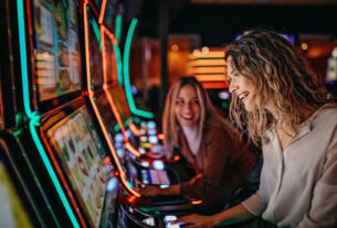 Girl friends gambling in casino on slot machinery